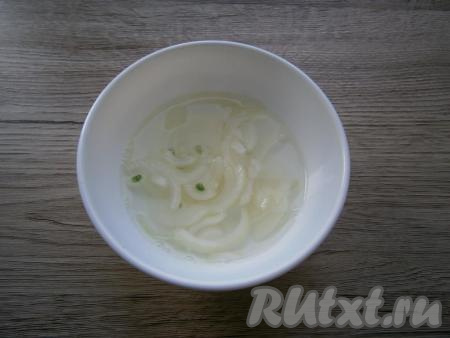 Очищенный лук нарезать тонкими полукольцами, залить кипятком и добавить 1 столовую ложку уксуса. Оставить лук для маринования на 20 минут.