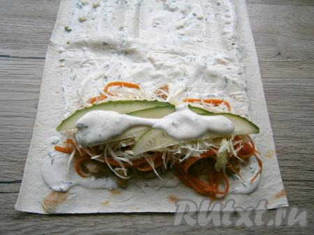 Капусту нарезать на тонкие полоски. Огурец промыть водой, отрезать кончики с двух сторон, затем нарезать на тонкие полоски. Поверх морковки выложить половину нарезанной капусты и половину нарезанного огурца. Сверху начинку шаурмы немного смазать соусом.