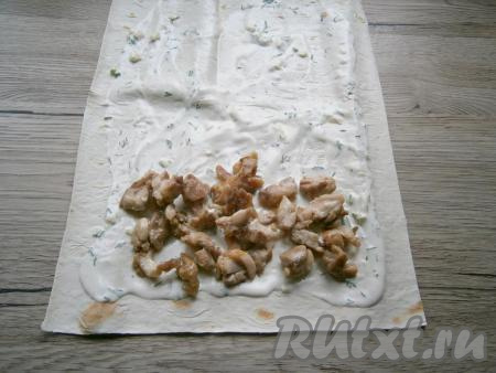 На один край смазанной части лаваша выложить половину ещё тёплого жареного куриного мяса.