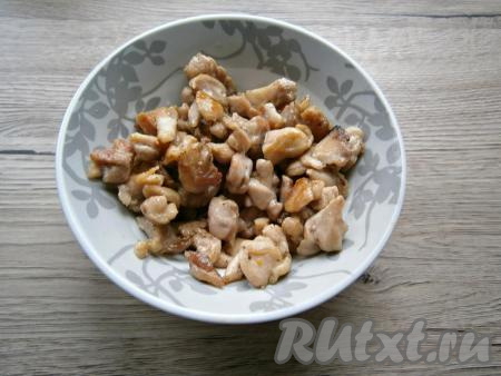 Куриное мясо (у меня - куриное филе) вымыть, обсушить, нарезать на небольшие кусочки, посолить, поперчить перемешать, выложить в сковороду, разогретую с растительным маслом сковороду. Обжарить его со всех сторон на среднем огне до готовности (в течение минут 7-10), иногда перемешивая. Дать мясу курицы остыть.