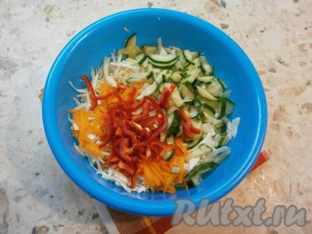 Болгарский перец очистить от семян и плодоножки. Огурец вымыть, отрезать кончики с двух сторон. К капусте и морковке добавить болгарский перец, нарезанный на тонкие полоски, и нарезанный брусочками свежий огурец.