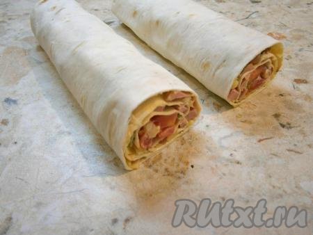 Свернуть лаваш в рулет поплотнее, завернуть в пищевую пленку и поместить в холодильник минут на 15-20, чтобы пропитался.