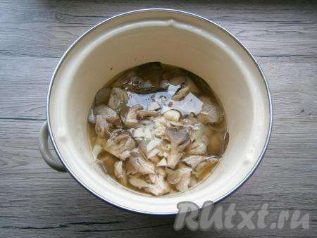 В кастрюлю с готовыми вешенками добавить очищенный и достаточно мелко нарезанный чеснок, аккуратно перемешать, довести до кипения и убрать с огня. Оставить грибы в кастрюле с маринадом до полного остывания.