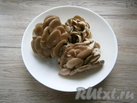 Пока маринад закипает, срезать у вешенок корешки, если они есть. Тщательно промыть вешенки под проточной водой.