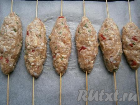Деревянные шпажки предварительно замочить в холодной воде минут на 10 (это делается для того, чтобы шпажки не тлели в процессе запекания люля в духовке). Сформировать на каждой шпажке люля-кебаб в виде продолговатой котлеты (я сформировала 6 штук) и выложить на противень, застеленный пергаментом.