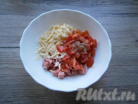 Помидор вымыть, по желанию, снять с него кожуры. К сыру и колбасе добавить помидор, нарезанный на небольшие кубики, поперчить, перемешать.