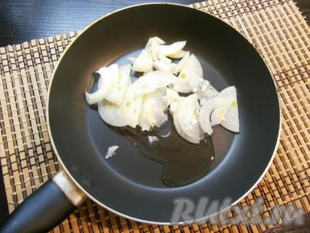 Репчатый лук очистить, нарезать тонкими полукольцами. Сковороду разогреть с растительным маслом и выложить в неё лук.