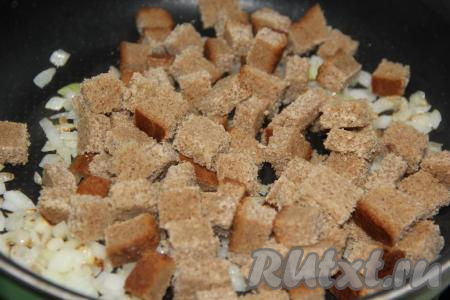 Хлеб нарезать на мелкие кубики и добавить в сковороду к луку. Обжарить в течение 5-7 минут, периодически помешивая.