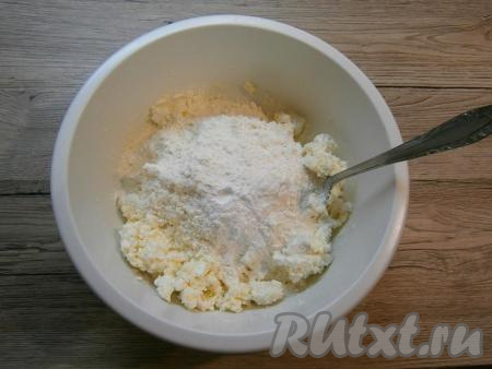 В миску с получившейся творожной массой добавить весь разрыхлитель, всыпать 150 грамм муки, перемешать творожное тесто столовой ложкой. Начать понемногу добавлять оставшуюся муку, каждый раз хорошо вмешивая её в тесто. После того как перемешивать ложкой станет сложно, продолжайте замешивать тесто руками.&nbsp;