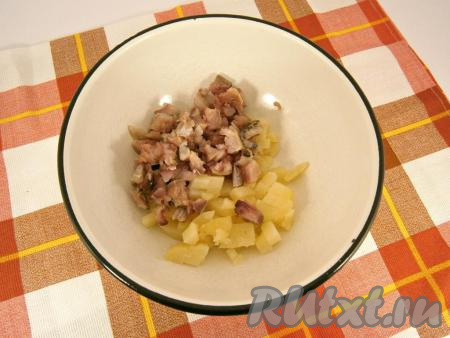 Филе сельди нарезать небольшими кусочками в миску, добавить нарезанный кубиками картофель.