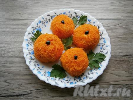 Из чёрной маслины вырезать маленькие кусочки и вставить их сверху, чтобы закуска была как можно более похожа на мандарины. Украсить тарелку с "мандаринками" любой зеленью.