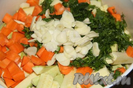 Очищенный чеснок нарезать на тонкие лепестки и добавить к кабачкам, моркови и зелени.