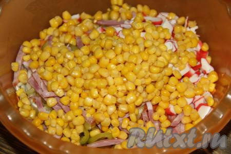 С кукурузы слить жидкость. Крабовые палочки и кукурузу добавить в салат, посолить по вкусу.