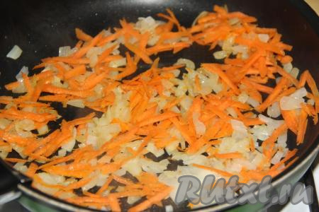 К обжаренному луку выложить морковку натёртую на крупной тёрке, перемешать овощи и обжаривать 4-5 минут, не забывая периодически помешивать.