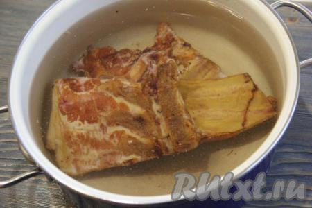 В кастрюлю выложить копчёные свиные рёбрышки, залить 2,5-3&nbsp;литрами холодной воды, поставить на огонь. После закипания воды уменьшить огонь, с поверхности бульона убрать пену. Варить рёбрышки в течение 1 часа, периодически снимая пену.