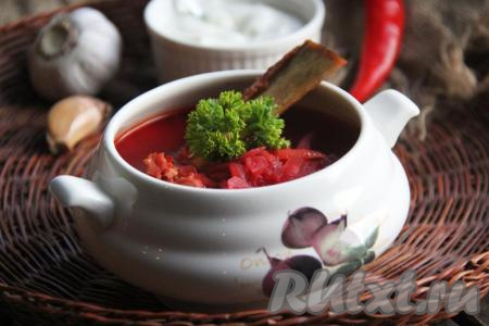 Очень вкусный, ароматный, яркий и сытный борщ с копчёными рёбрышками подать к столу. По желанию, в тарелки с борщом можно добавить зелень и сметану.