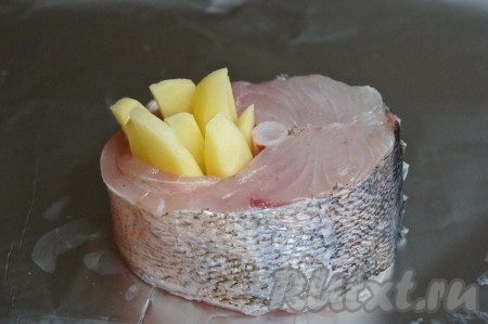 На фольгу кладем стейк судака и картофель так, как показано на фото.