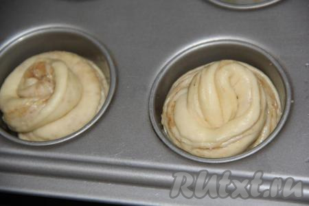 Формочки для кексов (я взяла металлические формочки) немного смазать растительным маслом. В каждую формочку выложить по одной части рулета по спирали, разрезом наружу. В результате получатся 10 кексов-краффинов. Оставить тесто в формах на 2 часа в тепле. Выбирая формочки, в которых будете выпекать краффины, обязательно учитывайте, что заполнять формочки нужно примерно на половину объёма, потому что дрожжевое тесто хорошо поднимется в процессе дальнейшей расстойки и выпечки.