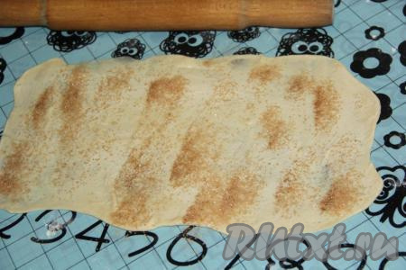Смесь сахара и корицы зрительно разделить на 5 равных частей. Смазать раскатанное тесто примерно 10 граммами мягкого сливочного масла, присыпать одной частью смеси сахара и корицы.