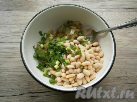 Из банки с фасолью слить жидкость. Фасоль и измельченный зеленый лук добавить в салат из языка и маринованных огурцов.