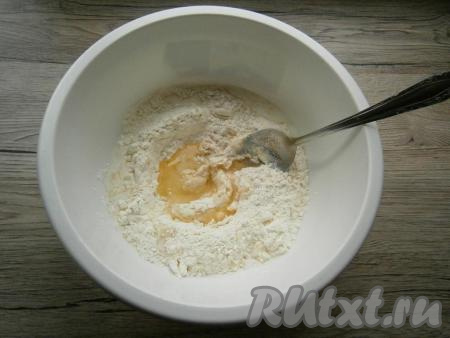 Влить растительное масло, перемешать столовой ложкой. Влить тёплый кефир, перемешать столовой ложкой.