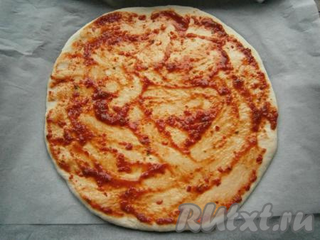 Пока тесто поднимается, можно подготовить начинку. Для получения фарша нужно кусочки любого мяса (у меня - куриное филе), пропустить через мясорубку. Если не хотите готовить фарш в домашних условиях, можете использовать покупной фарш. Получившийся фарш нужно выложить в миску, посолить, приправить специями (в качестве специй я использовала чёрный молотый перец и специи для мяса), тщательно перемешать. Поднявшееся тесто обмять, на столе, присыпанном мукой, раскатать в тонкую лепёшку, которую поместить на противень, застеленный пергаментом. Смазать лепёшку томатным соусом.