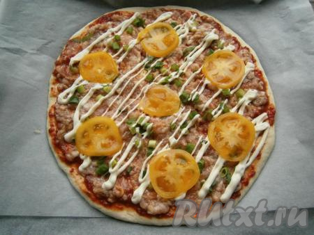 Помидор вымыть, нарезать на тонкие кружочки. Зелень (у меня - зелёный лук) мелко нарезать. Фарш смазать майонезом, затем равномерно распределить по лепёшке помидоры и зелень.