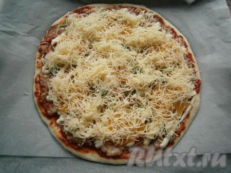 Сверху пиццу щедро посыпать сыром, натёртым на мелкой тёрке.