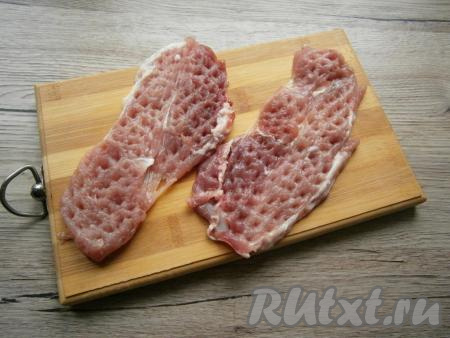 Мякоть свинины нарезать на части толщиной примерно 1-1,5 сантиметра. Каждую часть отбить кулинарным молоточком до толщины примерно 0,5 сантиметра.