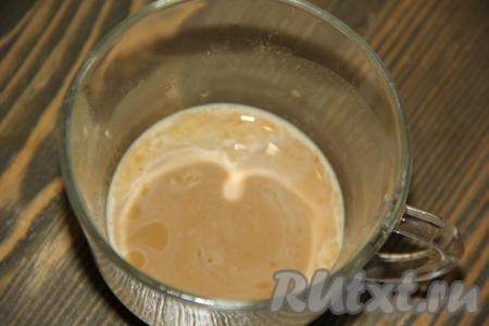 300 миллилитров воды подогреть до тёплого состояния. Температура воды должна быть не выше 40 градусов, чтобы дрожжи не погибли. В чашку влить 4-5 столовых ложек тёплой воды (от общего объёма 300 миллилитров), всыпать сухие дрожжи, тщательно перемешать и оставить на 5-10 минут, чтобы дрожжи "ожили" (на поверхности должна появиться "шапочка").