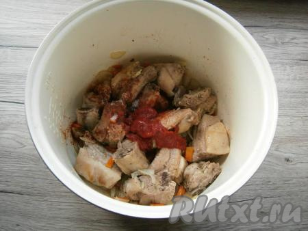 Выставить на мультиварке программу "Выпечка" на 20 минут. Обжаривать рёбрышки, периодически перемешивая, в течение 10 минут, после чего добавить к ним нарезанные кусочками репчатый лук и морковь. Обжаривать мясо с овощами, периодически перемешивая, оставшиеся 10 минут. Затем добавить в чашу томатную пасту, всыпать сахар.