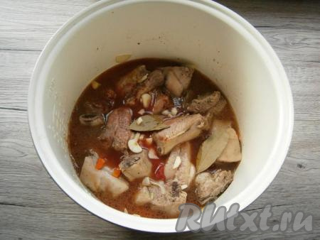 Влить в чашу 300 миллилитров горячей воды, добавить нарезанный чеснок, лавровые листья.