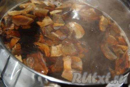 В кастрюлю влить грибной настой, добавить 1 литр воды и выложить нарезанные грибы. Поставить кастрюлю на огонь, довести до кипения и, убавив огонь, варить сушеные грибы в течение 35 минут.