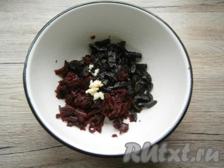 К свекле добавить чернослив, нарезанный небольшими кусочками, и чеснок, пропущенный через пресс.