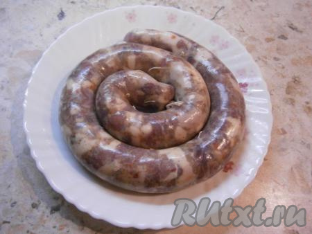 Свиные кишки, очищенные и промытые под проточной водой (для того чтобы промыть кишки, один конец кишки нужно надеть на гусак крана и промыть кишку проточной водой), не слишком плотно наполнить фаршем. Наполнить кишки фаршем можно с помощью специальной насадки для мясорубки (или же с помощью отрезанной верхней части пластиковой бутылки с горлышком), на которую нужно надеть кишку с одной стороны. Концы наполненной кишки перевязать с двух сторон. Сложить колбасу спиралью.