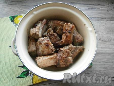 Обжарить свиные ребрышки на среднем огне на растительном масле до легкой румяной корочки со всех сторон и поместить их в кастрюлю.