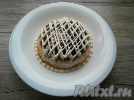 Перед подачей салат "Сельдь под шубой" перевернуть на тарелку или блюдо, убрать аккуратно пленку. Теперь верхний слой свеклы смазать майонезом в виде сеточки.