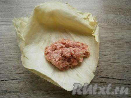 Затем листья сложить стопочкой и поместить их снова в микроволновку еще минут на 10 при той же мощности. После этого листья остудить и срезать утолщения. На каждый капустный лист выложить по 2 столовые ложки подготовленного фарша.
