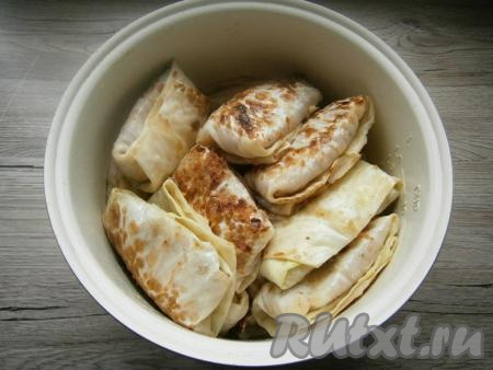 Обжарить голубцы на растительном масле на сковороде до румяности с двух сторон и поместить их в чашу мультиварки.