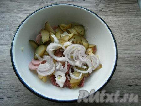 Очищенный лук, нарезанный тонкими полукольцами, и маринованный огурец, нарезанный кружочками или полукружочками, выложить в салат из картофеля, сосисок и колбасы.