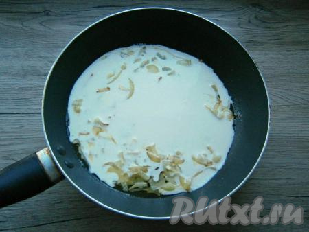 К обжаренному луку влить сметанный соус.