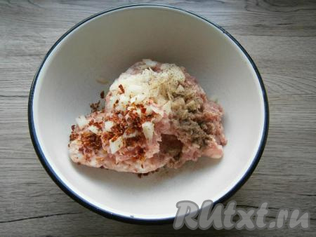 Лук очистить, половину луковицы мелко нарезать и выложить к фаршу, добавить соль, черный молотый перец и паприку.