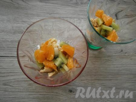 Затем выложить кусочки печенья, дольки мандарина и кусочки киви.