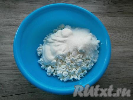 К творогу добавить сметану и всыпать сахар.