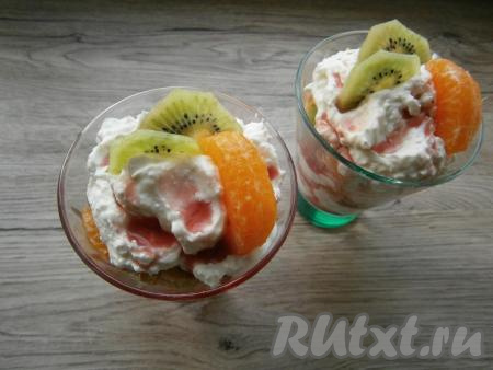 Затем слои повторить: творожная масса, политая сиропом, печенье, кусочки фруктов и так далее. Верхний слой должен быть творожным, полить его сиропом и украсить кусочком киви и долькой мандарина.