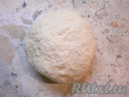 Быстро, но аккуратно, горячее масло вмешать в тесто. Затем на стол насыпать 0,5 стакана муки, выложить на нее мягкое тесто и вымесить его до плотного состояния. Тесто прикрыть пленкой и оставить на 20 минут.