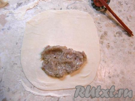 Далее разделить тесто на небольшие части. Каждую часть теста тонко раскатать, подсыпая муку. Разместить на каждом раскатанном кусочке теста по 1-2 столовой ложке фарша.
