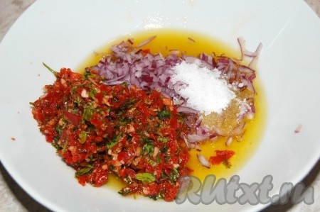 Смесь из перца, чеснока и петрушки переложить в достаточно глубокую миску, добавить нарезанный лук, соль, чёрный молотый перец, влить смесь масла и уксуса.