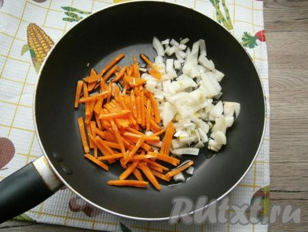Морковку и лук очистить. Лук нарезать кусочками, морковь - тонкой соломкой, поместить овощи в сковороду, влить растительное масло.