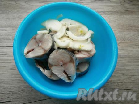 Нарезать подготовленную скумбрию на кусочки шириной около 2 см. Очищенный лук нарезать полукольцами и выложить к рыбке.